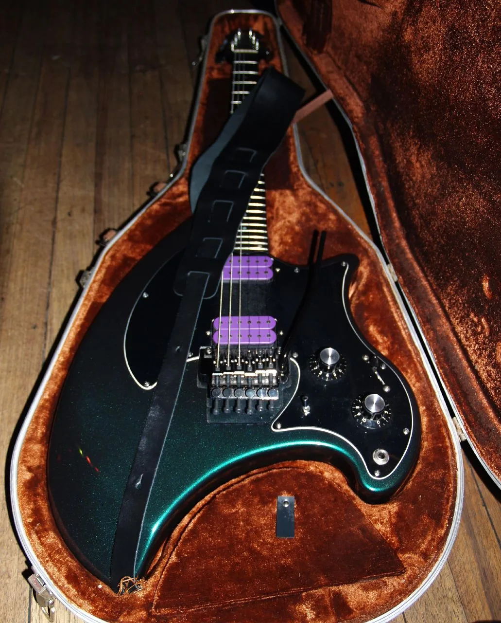 Ovation Breadwinner solidbody in green sparkle finish, resting in an open hardshell case